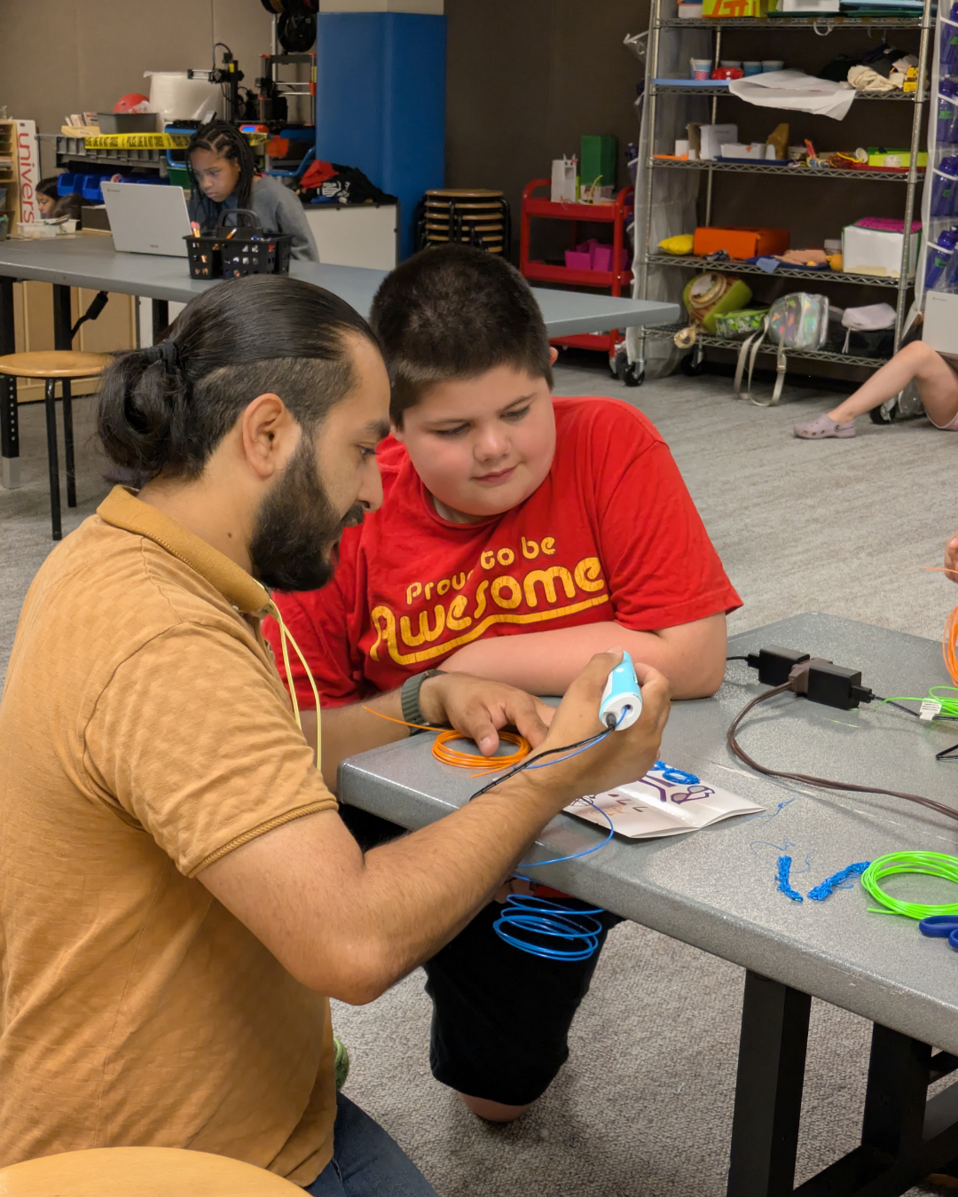 Instructor teaching a camper how to use a 3D pen