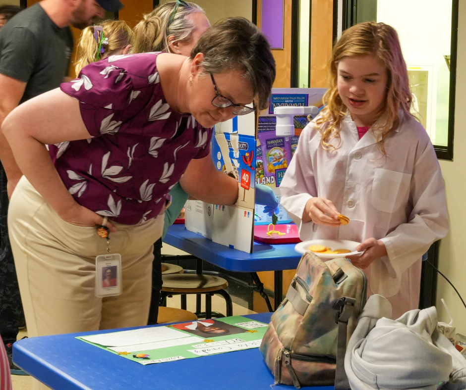 Mini med school campers and their adults take turns practicing "surgery" with pretend play.