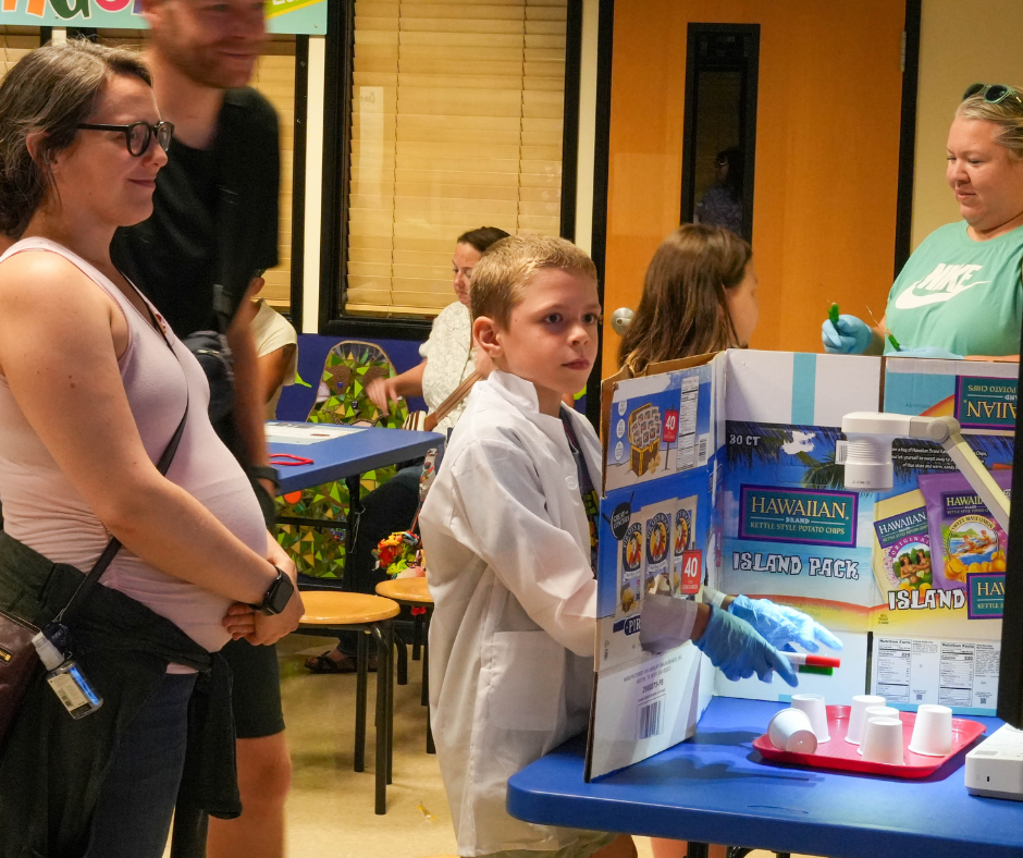 Mini med school campers and their adults take turns practicing "surgery" with pretend play.