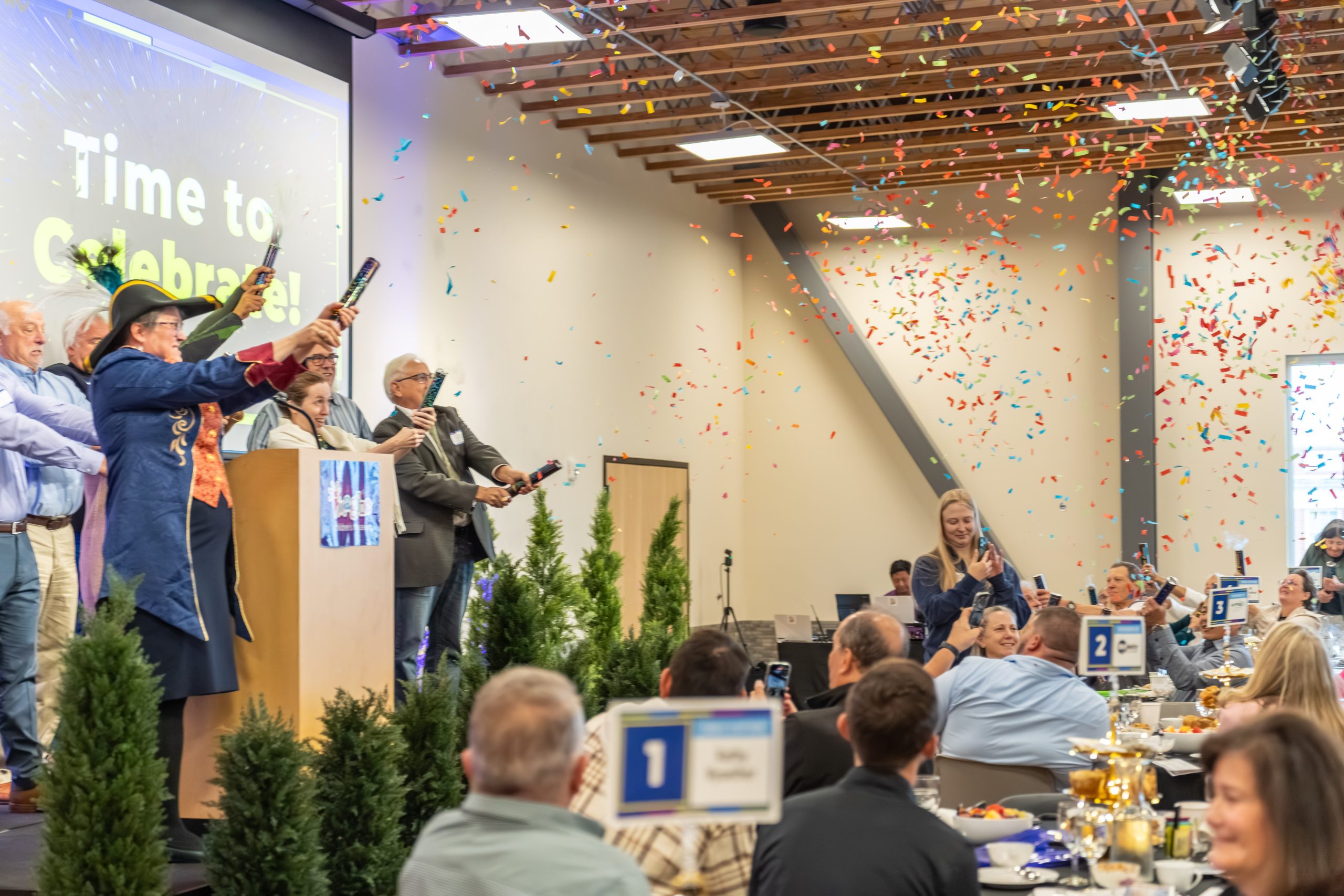 Guests celebrating beneath a burst of confetti at the Champions for Children Fundraising Breakfast